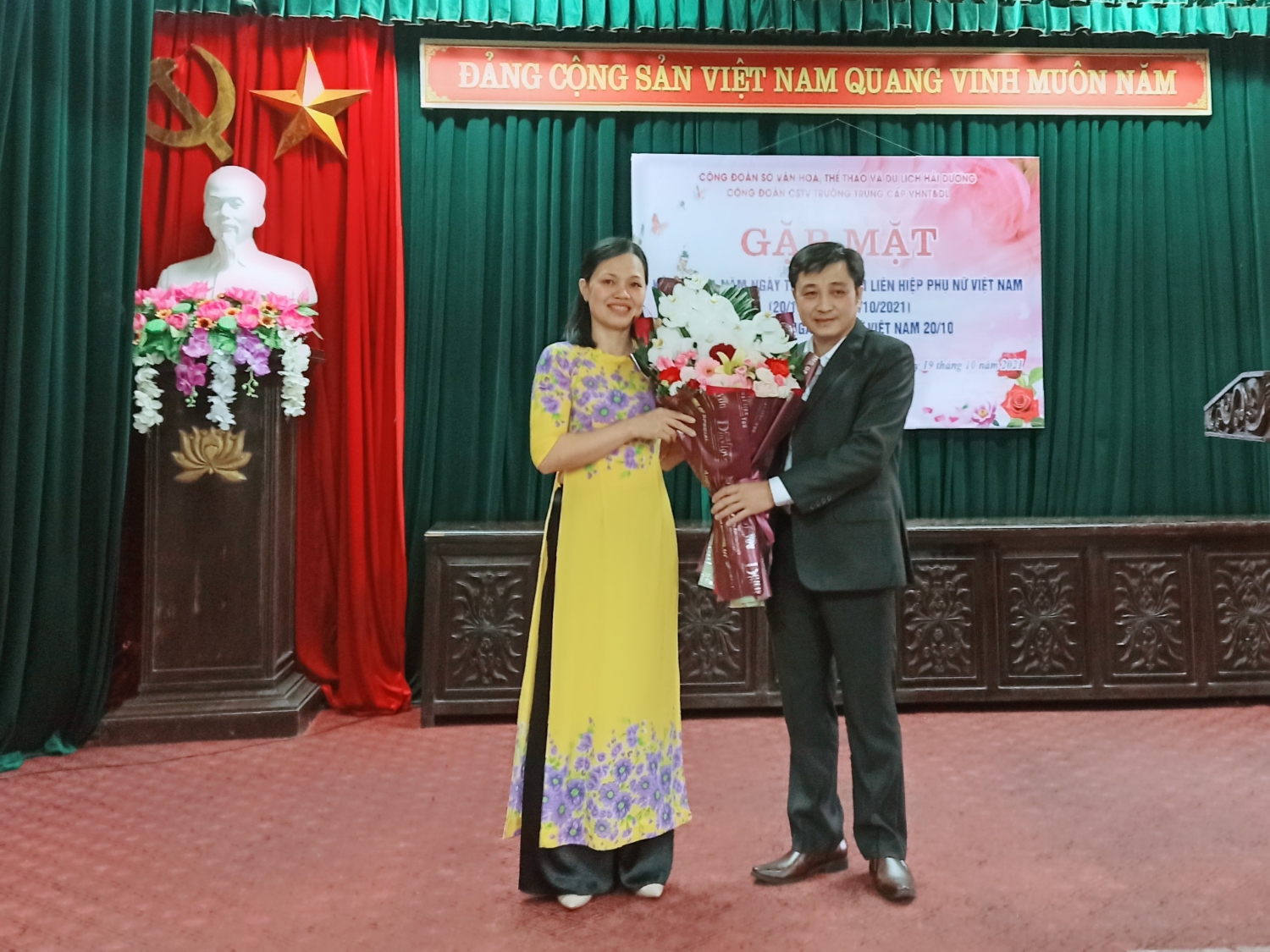 Đồng chí Mai Xuân Tuấn - Bí thư chi bộ, Hiệu trưởng nhà trường tặng hoa chúc mừng tập thể nữ cán bộ, giáo viên, nhân viên nhà trường